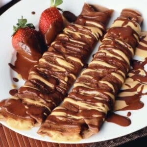 Chocolate Peanut Butter Cup Crepes with fresh strawberries on a plate
