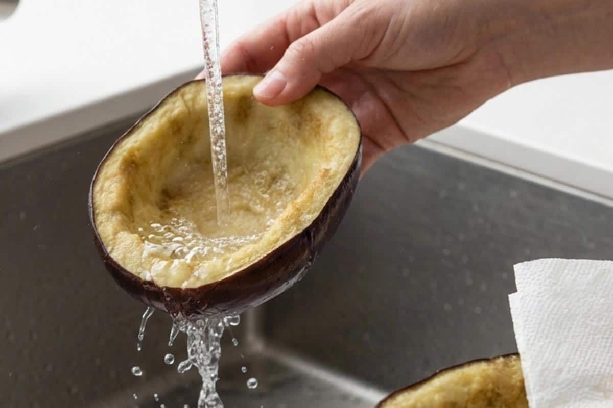 Rinsing the salt from the eggplant shells.