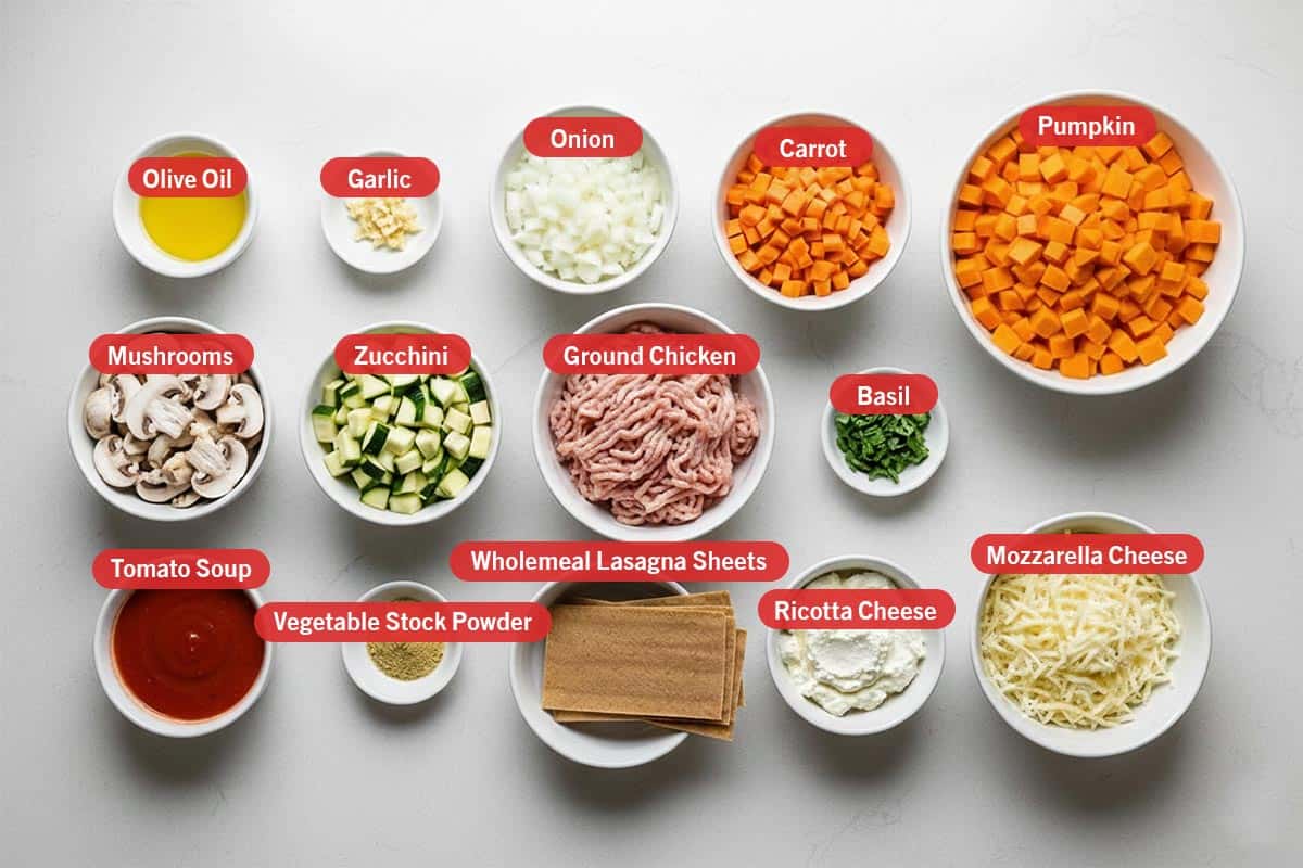 Top shot of ingredients: olive oil, garlic, onion, carrot, pumpkin, mushroom, zucchini, ground chicken, basil. tomato soup, vegetable sTock powder, wholemeal lasagna sheets, ricotta cheese, and mozzarella cheese. - 2