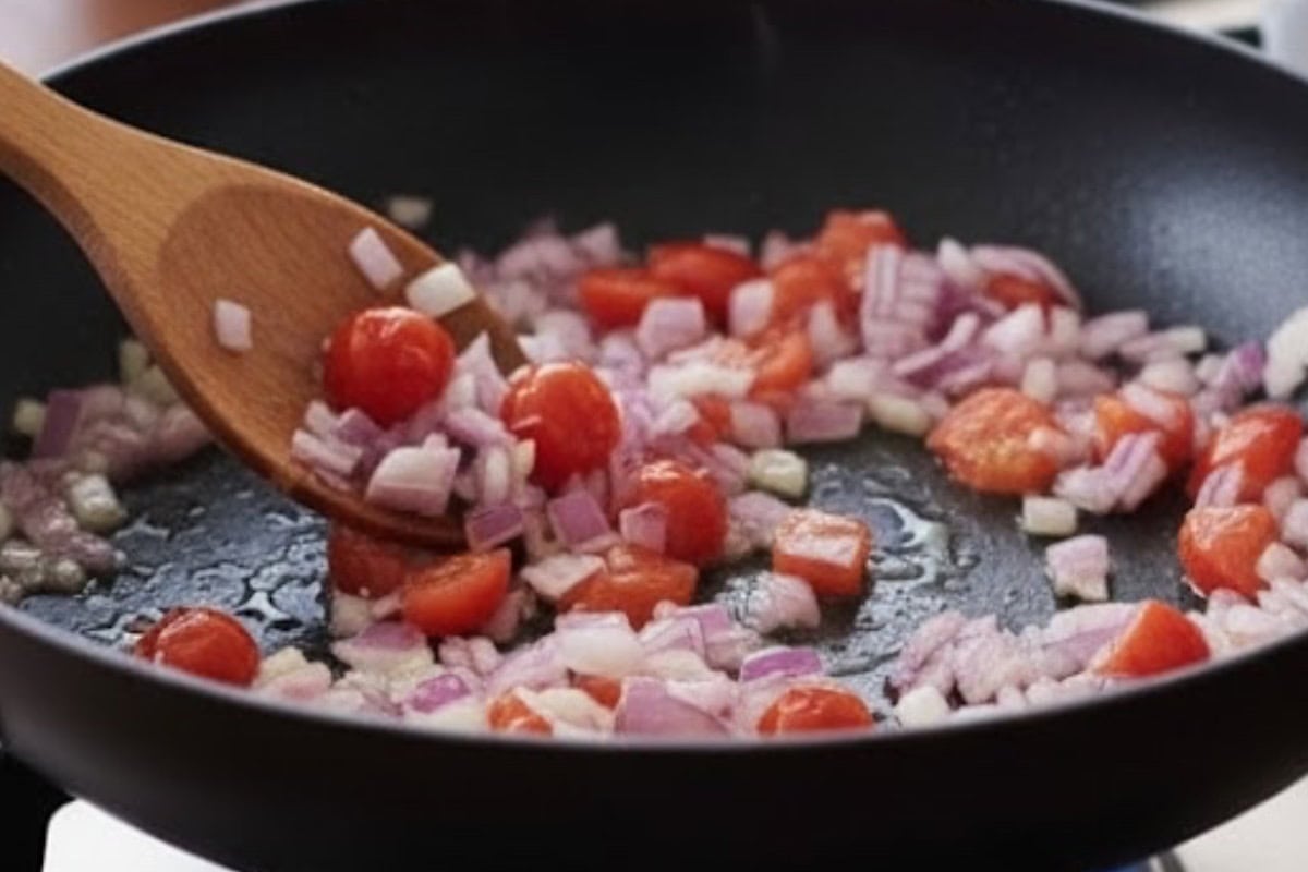 Add the diced onion and tomatoes, stirring occasionally until the onion turns transparent