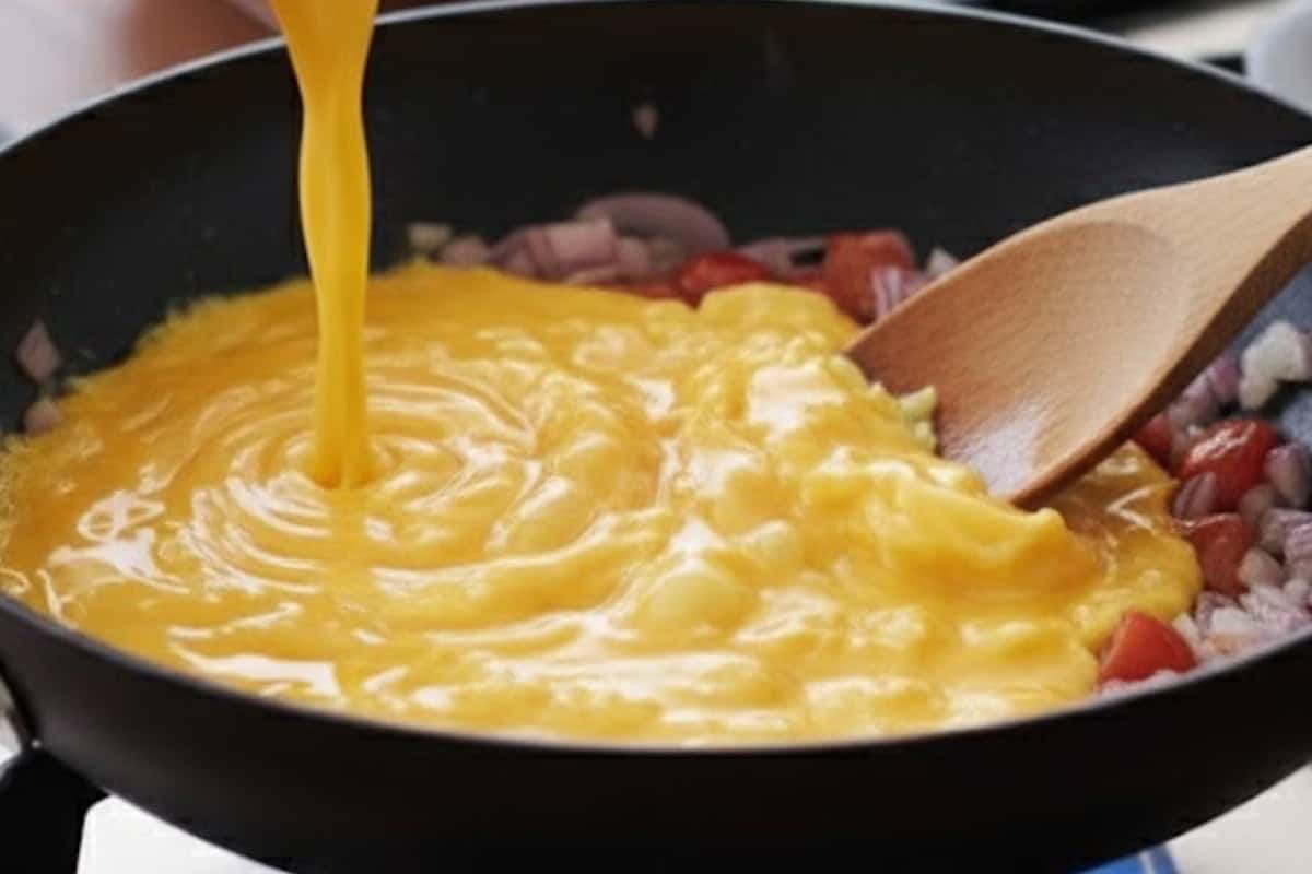 Pour in the whisked eggs and gently stir for 1 to 2 minutes, keeping the texture light and fluffy.