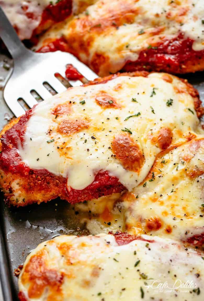 The Best Chicken Parmesan with a deliciously crispy breadcrumb coating, smothered in a rich homemade tomato sauce and melted mozzarella cheese! This is here best Chicken Parmesan you will ever make! Simple to make and worth every minute. If you love a crispy crumb coating vs soggy crumb, look no further! | cafedelites.com
