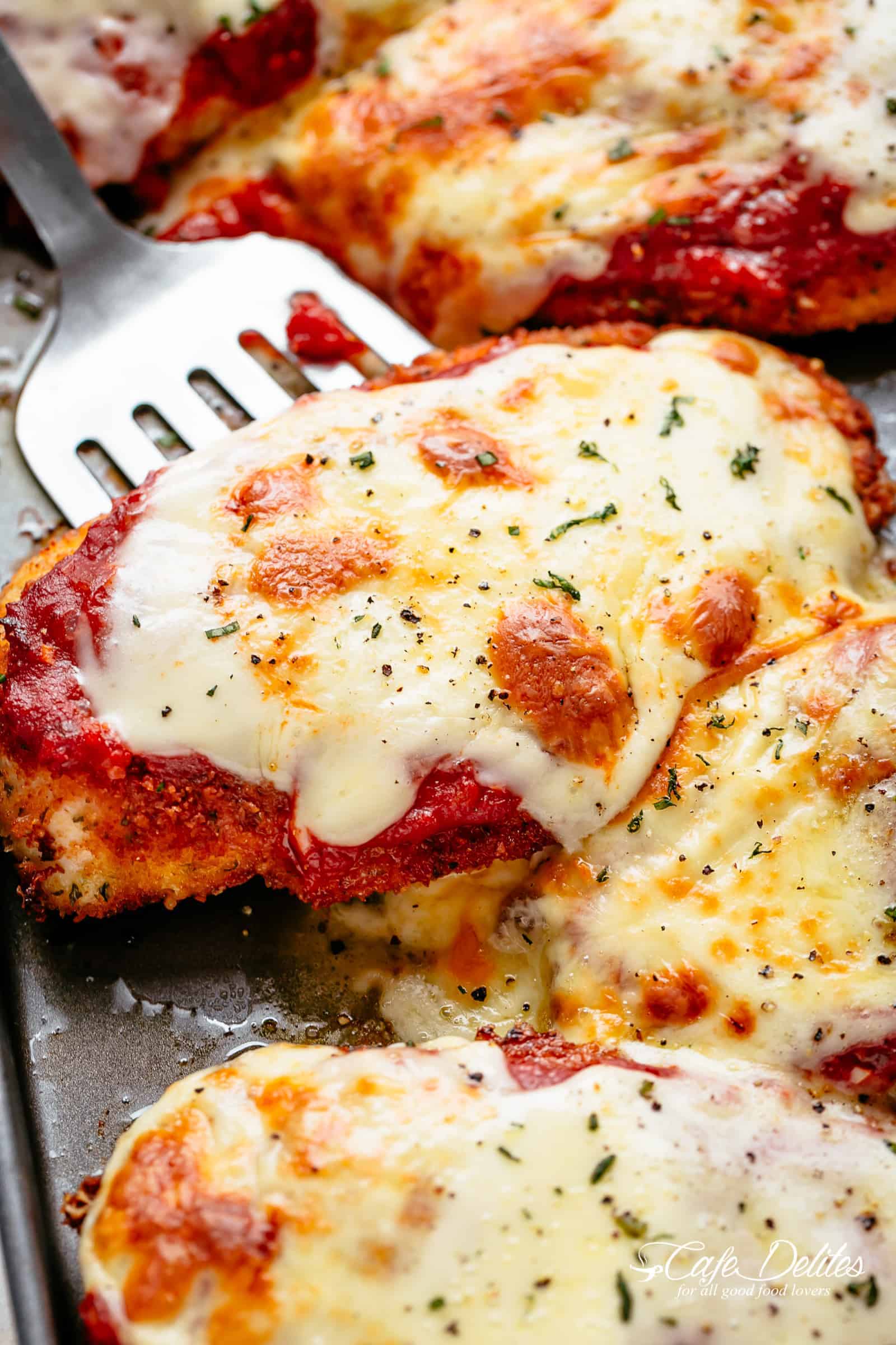 The Best Chicken Parmesan with a deliciously crispy breadcrumb coating, smothered in a rich homemade tomato sauce and melted mozzarella cheese! This is here best Chicken Parmesan you will ever make! Simple to make and worth every minute. If you love a crispy crumb coating vs soggy crumb, look no further! | cafedelites.com