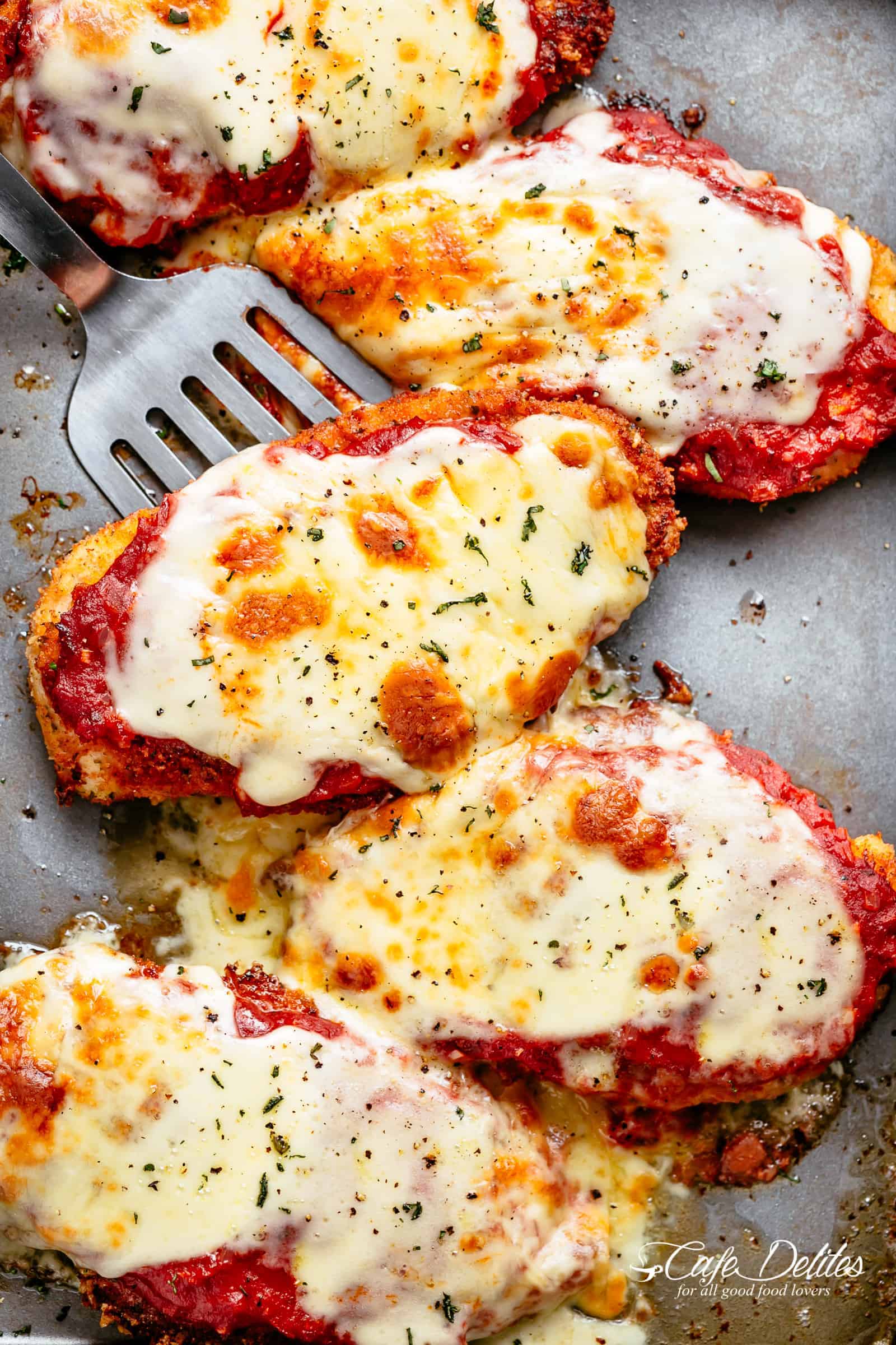 The Best Chicken Parmesan with a deliciously crispy breadcrumb coating, smothered in a rich homemade tomato sauce and melted mozzarella cheese! This is here best Chicken Parmesan you will ever make! Simple to make and worth every minute. If you love a crispy crumb coating vs soggy crumb, look no further! | cafedelites.com