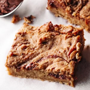 Jam and Nutella swirled blondie piece on parchment paper