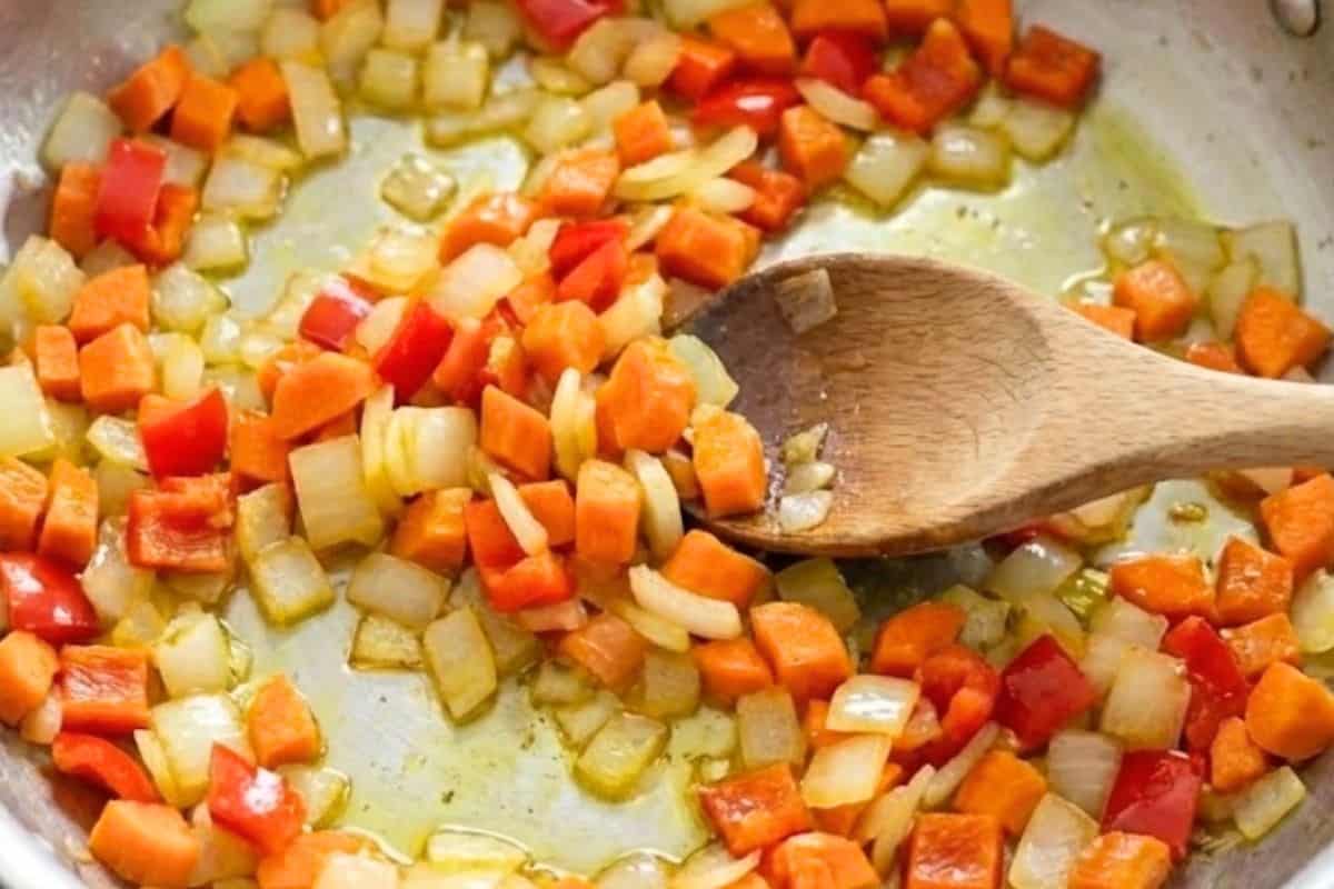 Heat the oil in a large pan over medium high heat and add the onion, carrots, and capsicum.