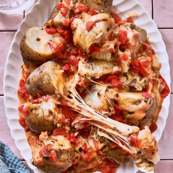 Cheesy Potatoes, also known as Papas Chorreadas on a white serving plate.