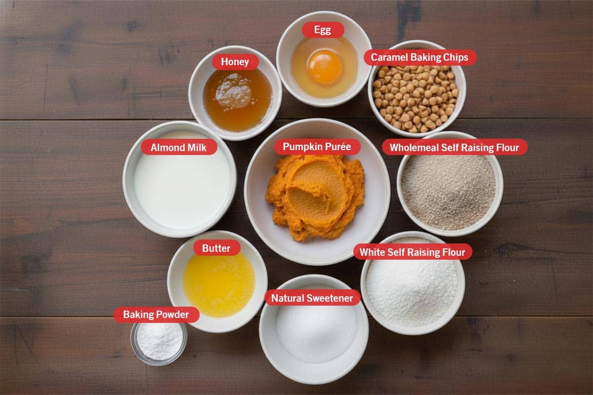 Top shot of ingredients: egg, caramel baking chips, wholemeal self raising flour, white self raising flour, natural sweetener, butter, baking powder, almond milk, honey, and pumpkin purée. - 2