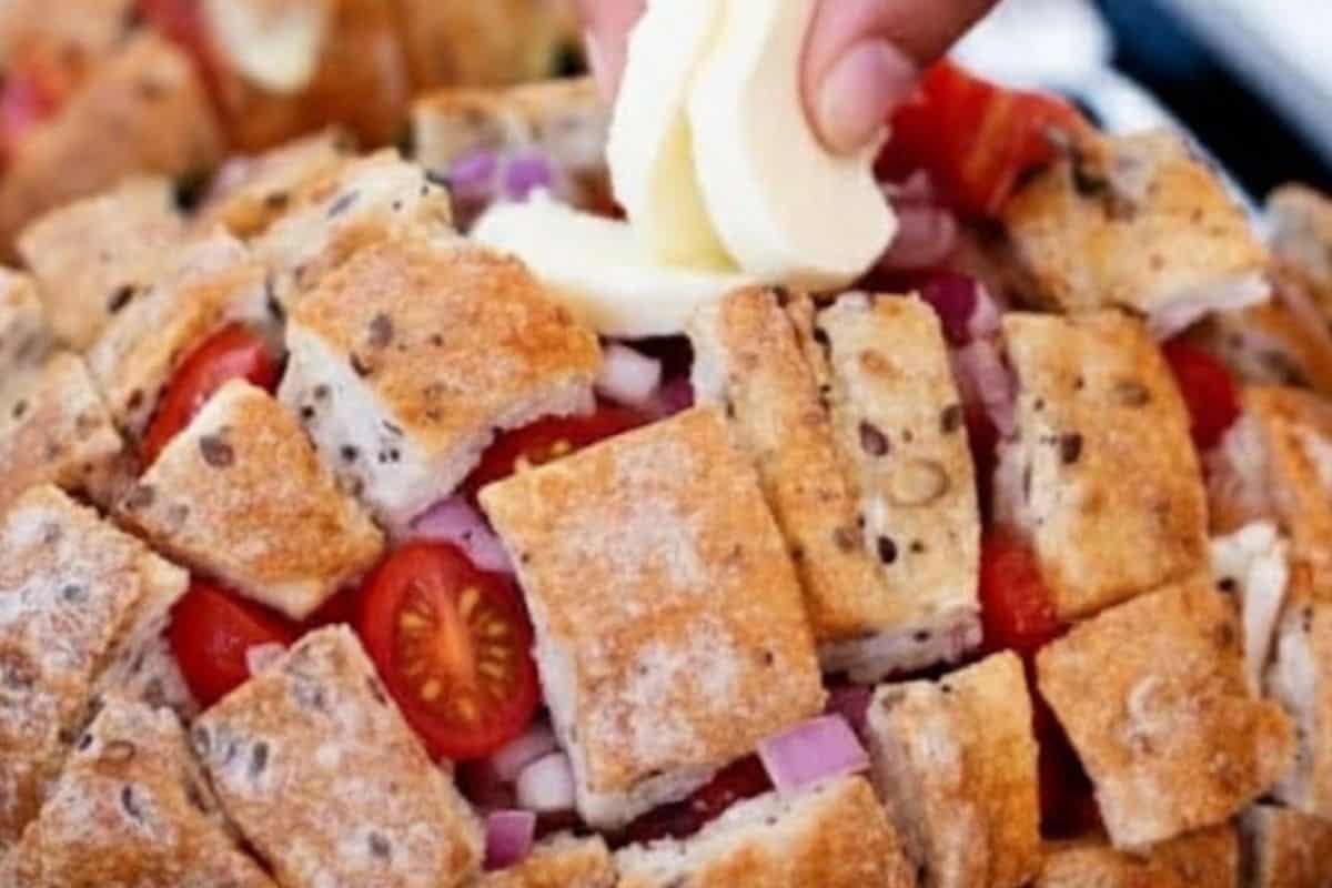 Stuff chopped onions into the cuts, tomatoes, then mozzarella