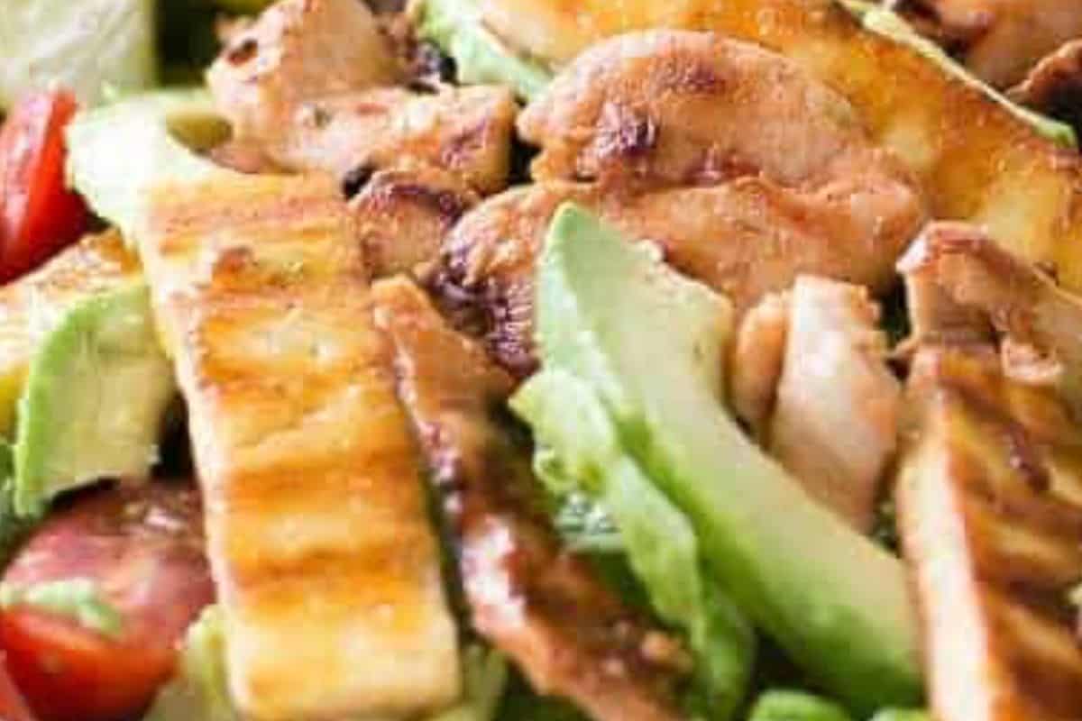 combine salad leaves, tomatoes, and avocado on plates, top with the warm chicken and halloumi, drizzle with dressing, and serve with lime wedges - 6