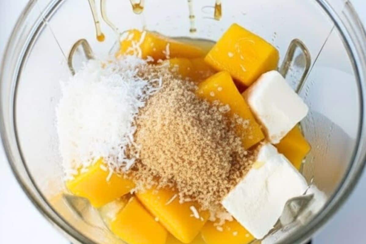 Add the mango, cream cheese, sweetener, honey, lemon juice, and shredded coconut to a blender. - 3