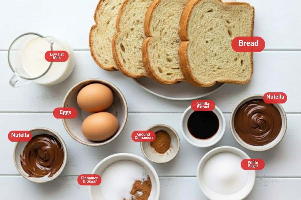 Flat lay photo of ingredient shot of low fat milk, bread, eggs, nutella, vanilla extract, cinnamon & sugar, white sugar, ground cinnamon