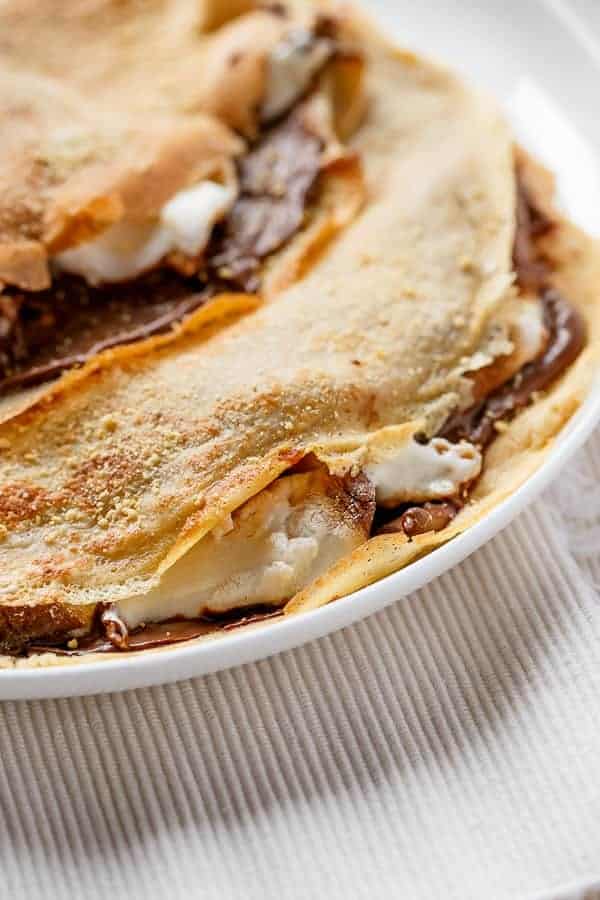 Beautiful golden Crepes full of Graham cracker crumbs Nutella S’mores Crepes