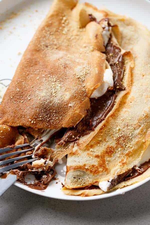 Beautiful golden Crepes full of Graham cracker crumbs Nutella S’mores Crepes