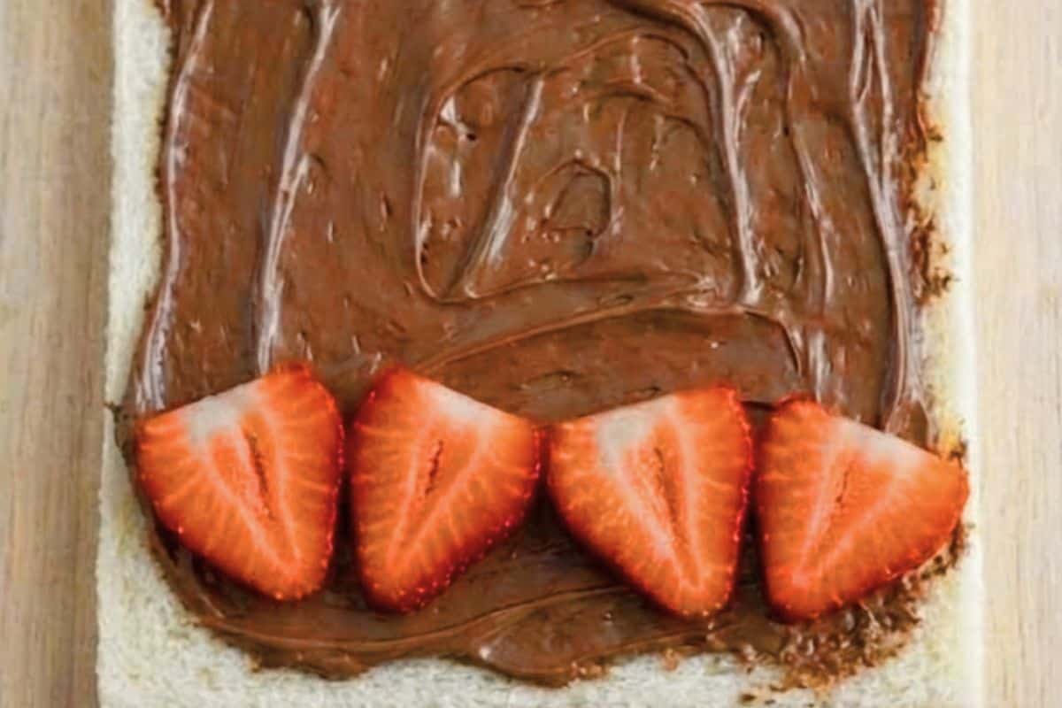Spread ½ tablespoon of Nutella onto each slice, then place fruit over one third of the bread - 5