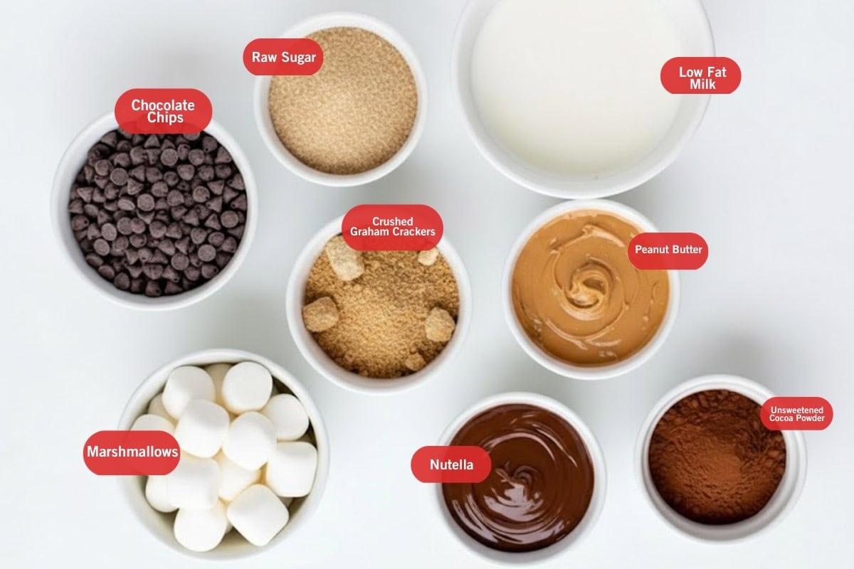 Flat lay photo of ingredient shot of chocolate chips, raw sugar, low fat milk, crushed graham crackers, peanut butter, marshmallows, nutella, unsweetened cocoa powder