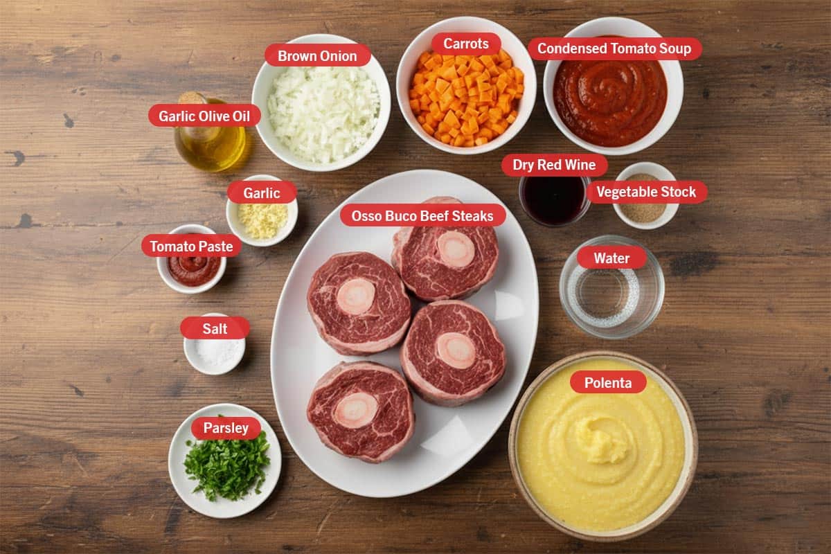 Top shot of ingredients: garlic olive oil, brown onion. carrots, tomato soup, dry red wine, vegetable stock, water, polenta, osso buco beef steaks, tomato paste, salt, and parsley.