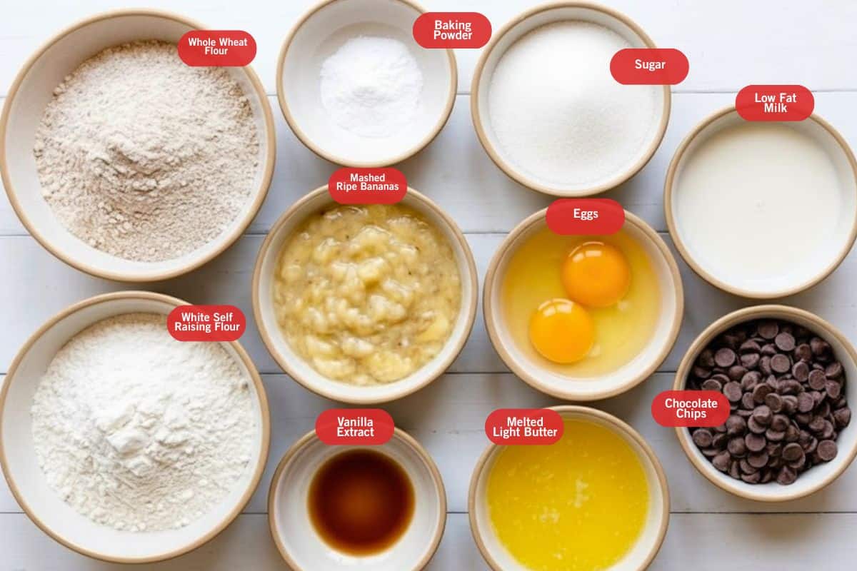 Flat lay photo of ingredient shot of whole wheat flour, baking powder, sugar, low fat milk, chocolate chips, eggs, melted light butter, vanilla extract, mashed ripe bananas, white self raising flour. - 2