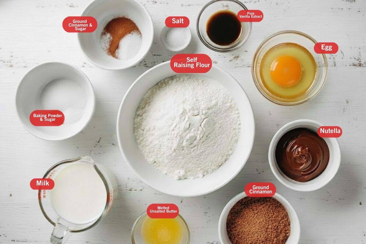 Flat lay photo of ingredient shot of ground cinnamon and sugar, salt, pure vanilla extract, egg, nutella, melted unsalted butter, baking powder, self raising flour