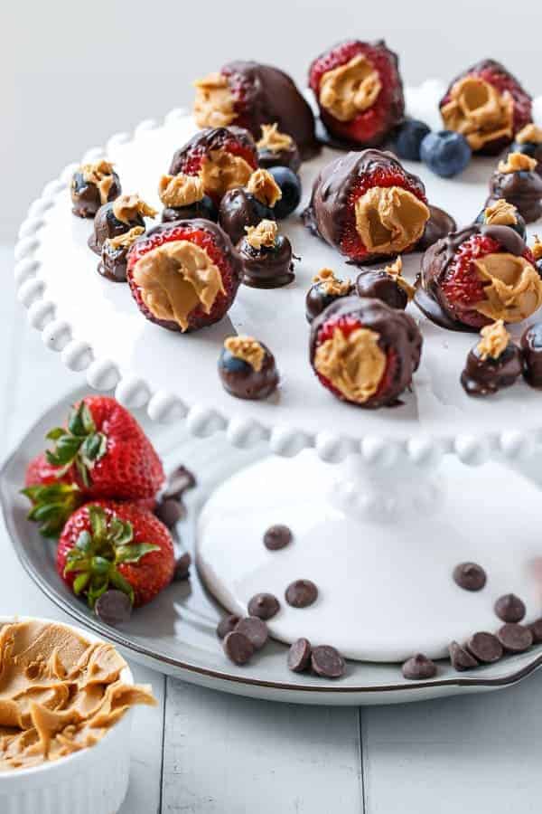 Peanut Butter Stuffed Chocolate Covered Berries on tray and some fresh strawberry kept aside 