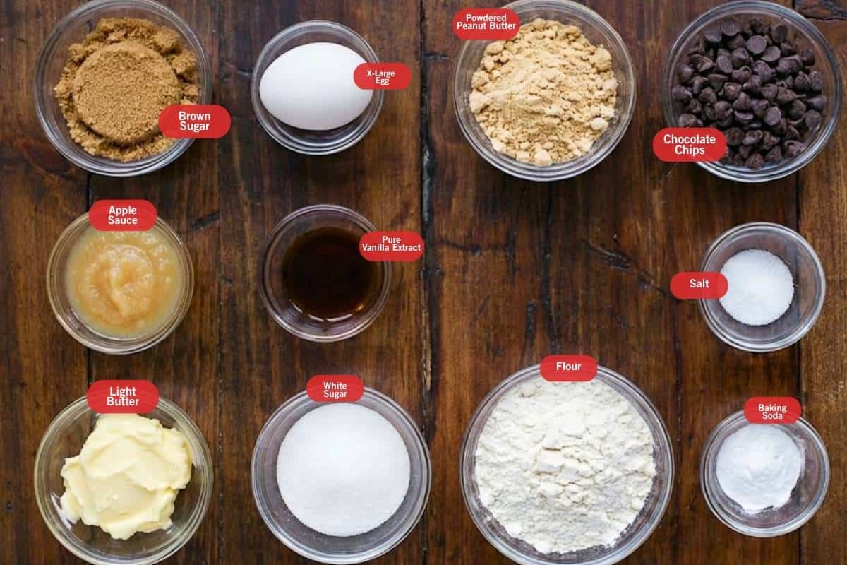Flat lay photo of ingredient shot of brown sugar, x- large egg, powdered peanut butter, chocolate chips, apple sauce, pure vanilla extract, salt, baking soda, flour, white sugar, light butter - 2