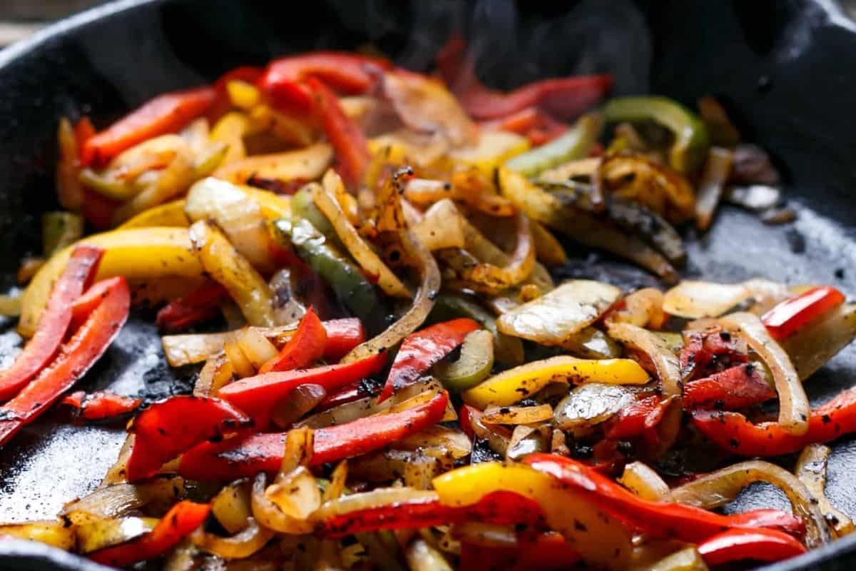 Heat a skillet with a little oil over medium high heat and cook the peppers and onion until vibrant - 6