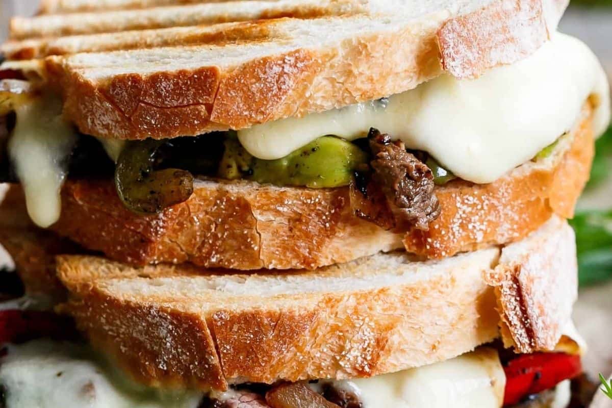Layer the bread with peppers, onions, sliced steak, yoghurt or sour cream, avocado and mozzarella, - 8