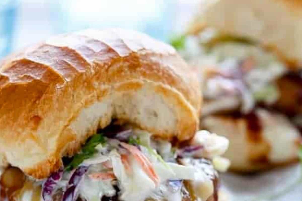 Stack patties onto the buns, pile with slaw, drizzle with extra barbecue sauce, and finish with parsley. - 10