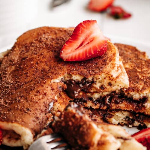 A slice of strawberry on a Chocolate Stuffed Churro Pancakes.