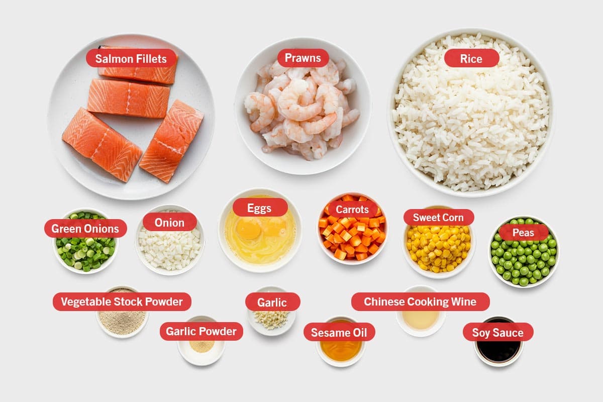 Top shot of ingredients: salmon fillets, prawns, rice, green onions, onion, eggs, carrots, sweet corn, peas, vegetable stock powder, garlic powder, garlic, sesame oil, chinese cooking wine, and soy sauce.
