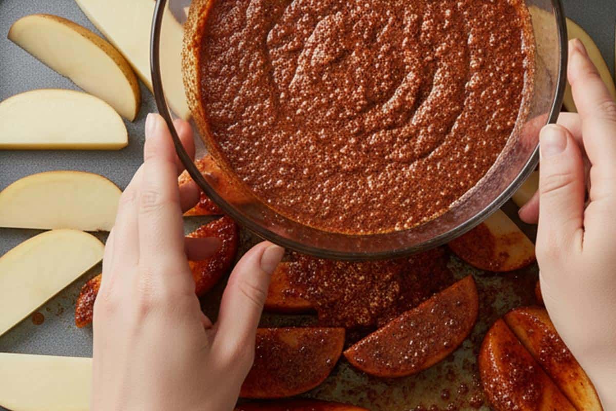 Coating the wedges with the seasoning mixture.