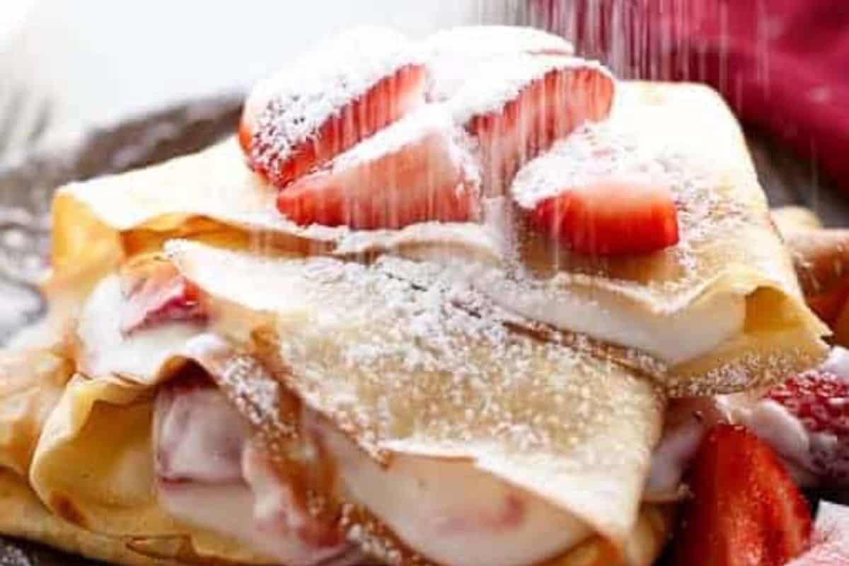 Spread the strawberry cream over a quarter of each crepe, fold into triangles, stack them, and spoon the remaining macerated strawberries on top.