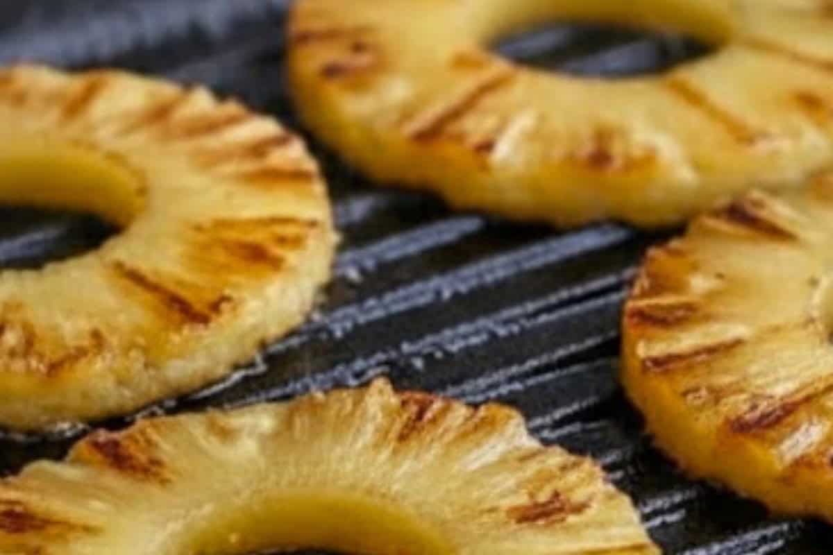 Once the patties are done cooking, fry the pineapple rings in the same pan for about a minute on each side, until they are caramelised and golden.