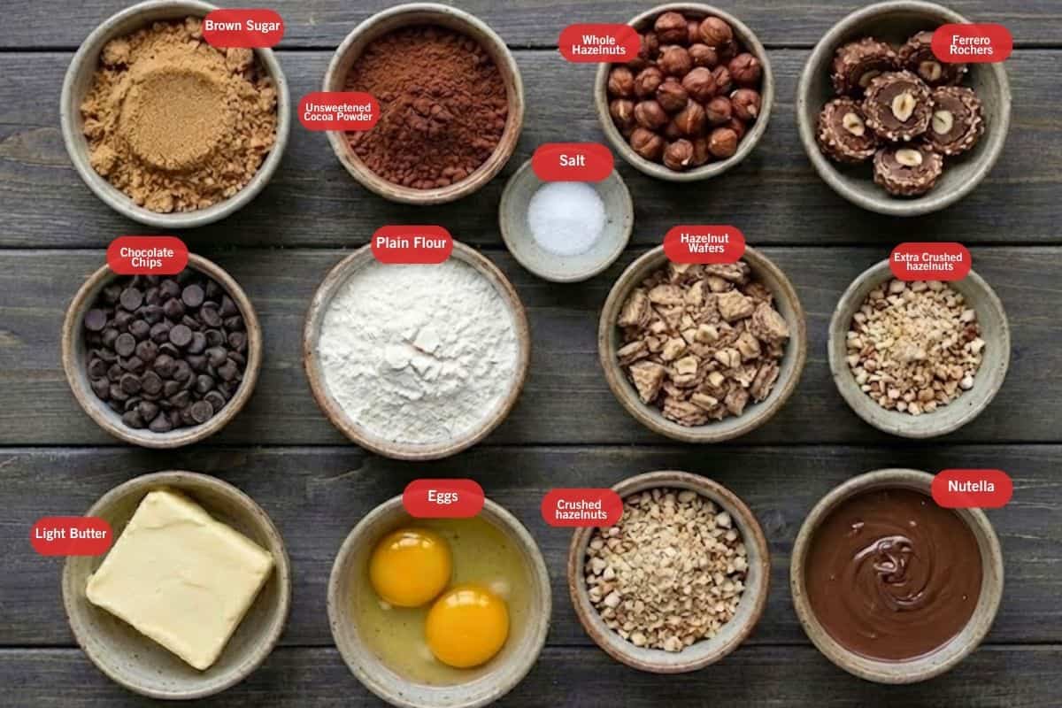Flat lay photo of ingredient shot of brown sugar, unsweetened cocoa powder, whole hazelnuts, Ferrero richer, chocolate chips, plain flour, salt, hazelnut wafers, extra crushed hazelnuts, eggs, light butter, nutella, crushed hazelnuts - 2