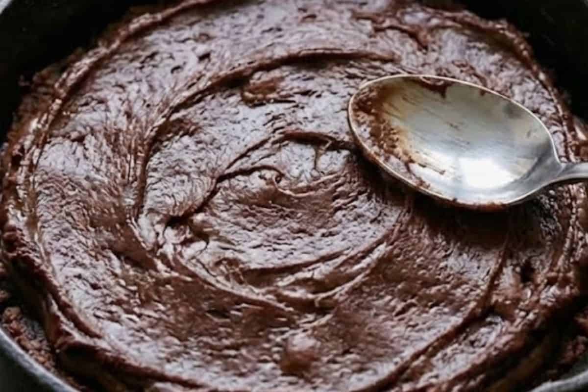 Sprinkle chopped hazelnut wafers and whole hazelnuts over the Nutella. Spoon remaining dough on top and smooth with the back of a spoon. - 9