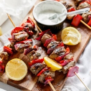 Greek Lamb Souvlaki with a Garlic Yogurt Dip on a wooden platter