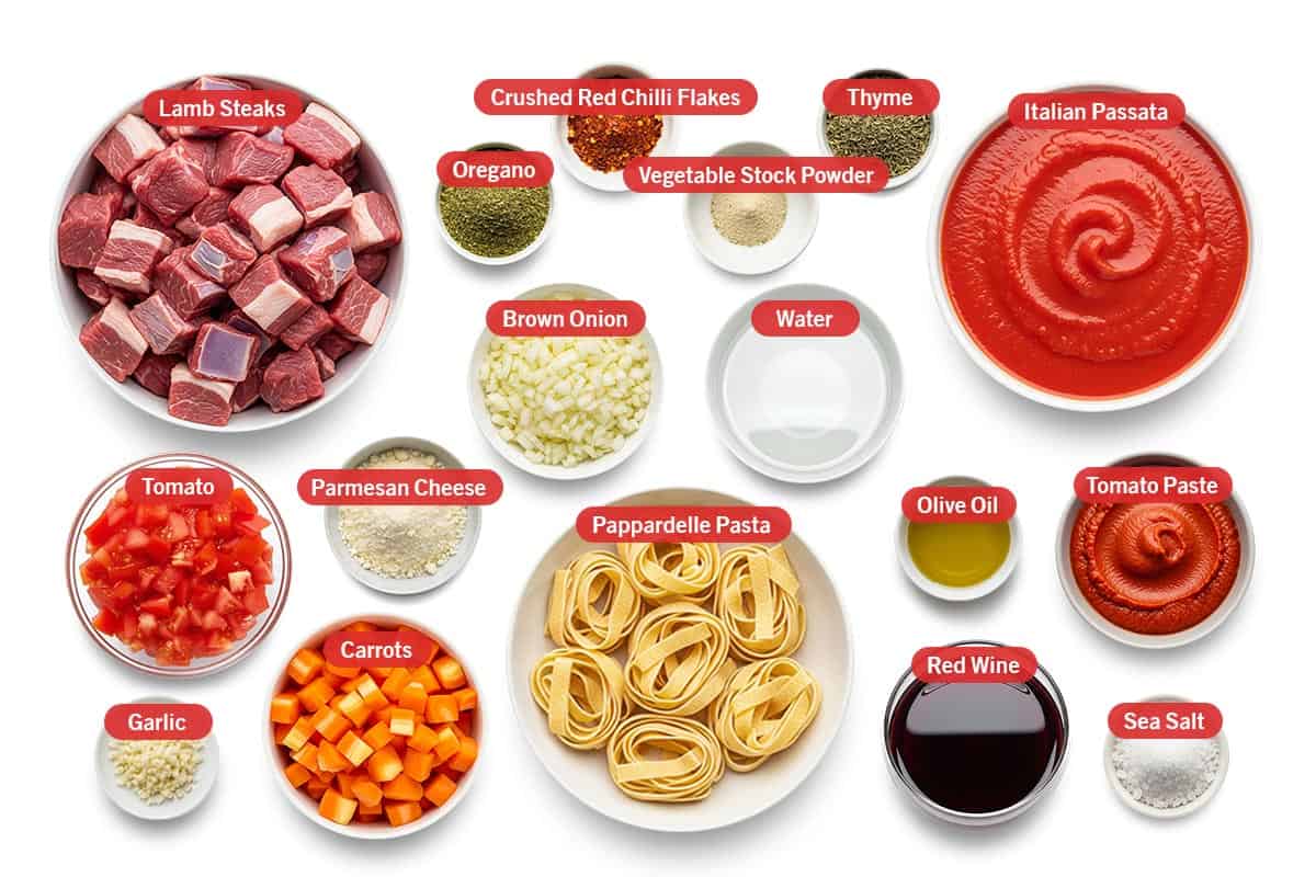 Top shot of ingredients: Lamb steaks, oregano, Crushed Red Chilli Flakes, vegetable stock powder, thyme, Italian Passata, brown onion, water, tomato, parmesan cheese, garlic, carrots, Pappardelle Pasta, olive oil, tomato paste, red wine, and sea salt.