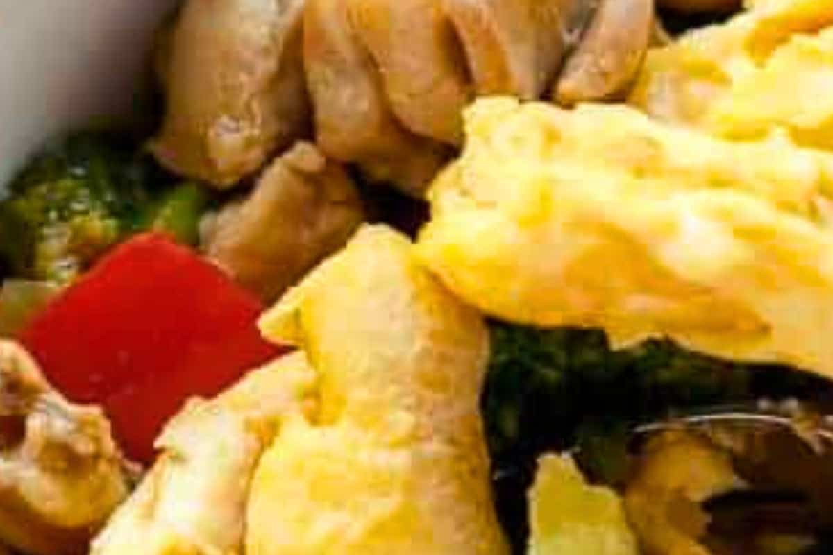 Whisk eggs with soy sauce, then heat sesame oil in a pan. Pour eggs, swirl to form a thin layer, cook for 2 minutes per side until golden, then serve over your chicken.