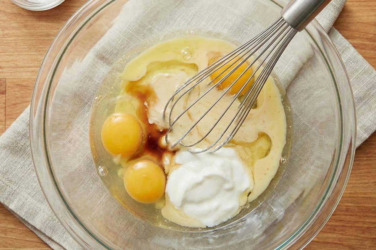 Whisking eggs, oil, vanilla and yogurt in a bowl. - 4