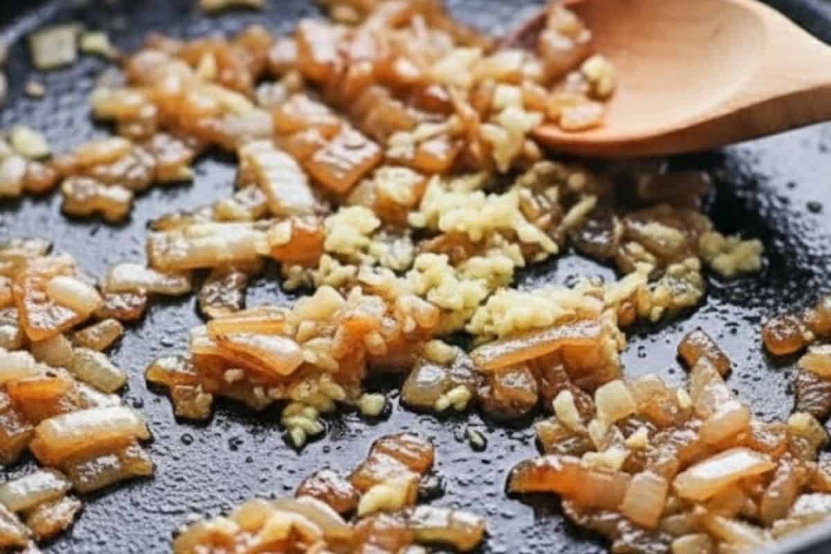 Heat olive oil in a large oven-proof pan over medium heat. Add chopped onion and garlic and sauté.