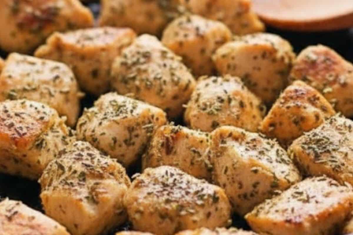 Add diced chicken pieces to the pan and sear until golden all over. Season with oregano, basil, parsley flakes, stock powder, and a pinch of salt to taste.