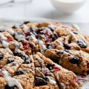 Mixed Berry and Chocolate Chunk Buttermilk Scones with a Cream Cheese Glaze on a tray