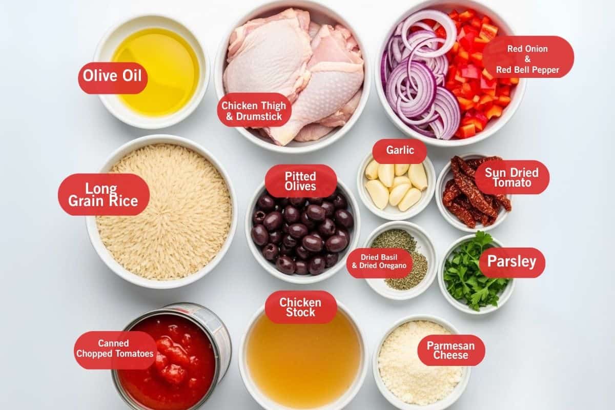 Flat lay photo of ingredient shot of olive oil, chicken thighs and drumstick, red onion and red bell pepper, long grain rice, pitted olives, garlic, sun dried tomato, parsley, dried basil and dried oregano, canned chopped tomatoes, chicken stock, parmesan cheese