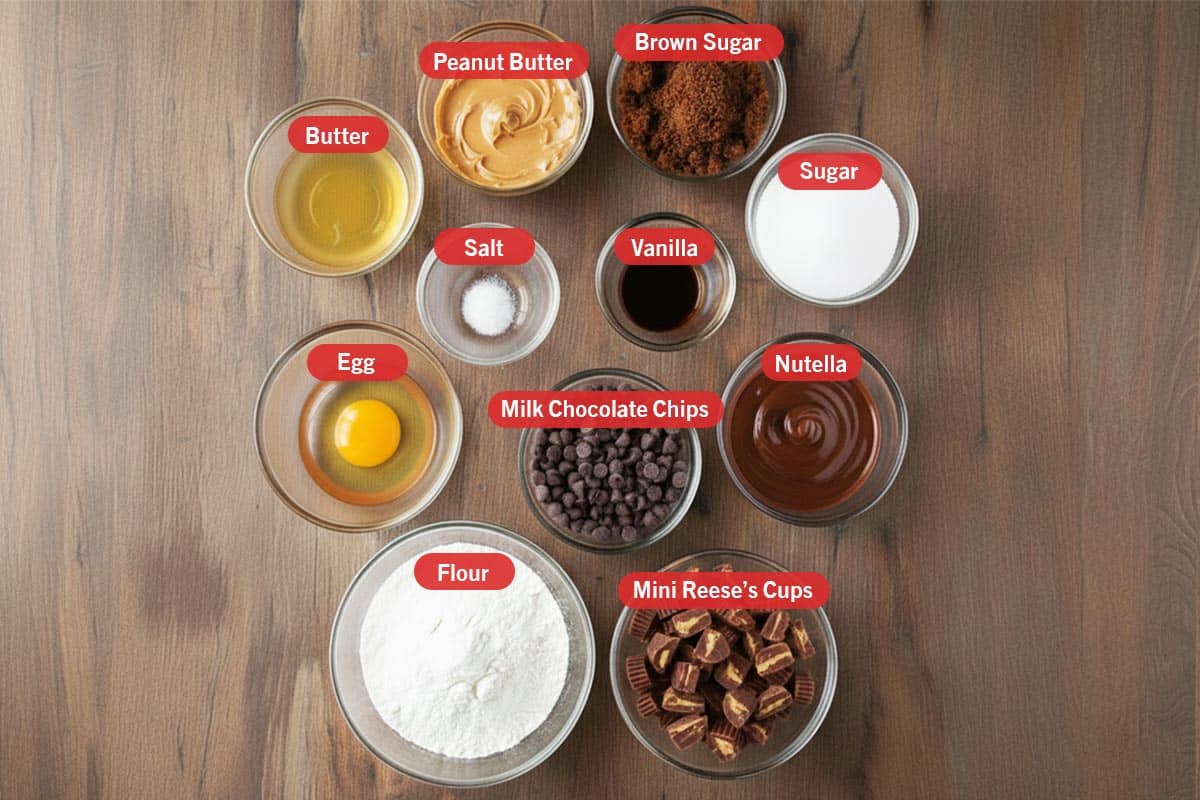 Top shot of ingredients: butter, peanut butter, brown sugar, sugar, egg, salt, vanilla, milk chocolate chips, nutella, flour, and mini Reese's cups. - 2