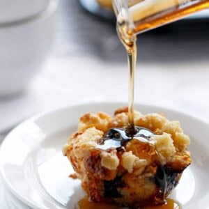 Maple syrup dripping over Blueberry Cheesecake French Toast Streusel Muffins