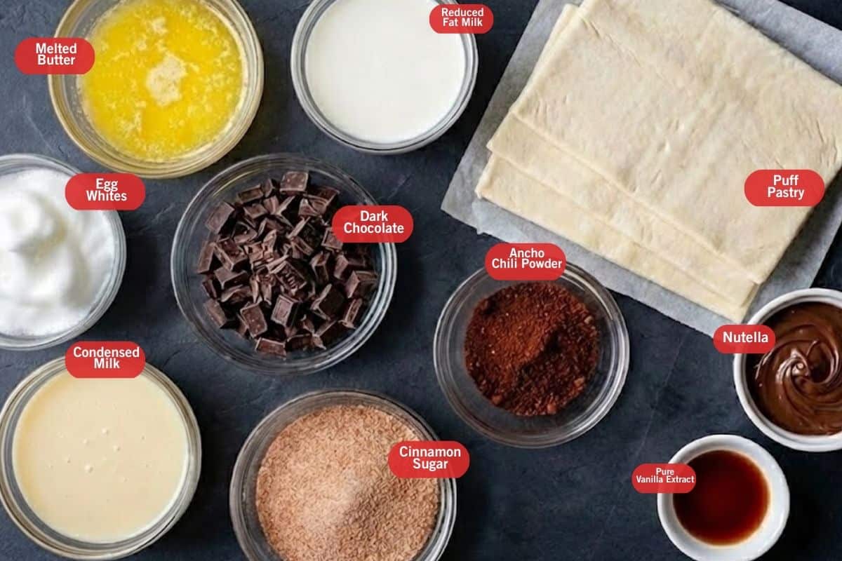 Flat lay photo of ingredient shot of melted butter, reduced fat milk, puff pastry, nutella, pure vanilla extract, cinnamon sugar, dark chocolate, condensed milk, egg whites - 2