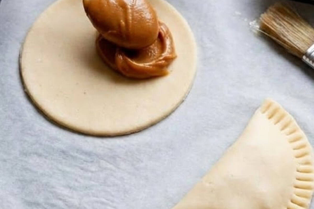 Spoon a tablespoon of Dulce de Leche onto one side of each circle, brush the edges with egg white, fold over, and press to seal. - 7