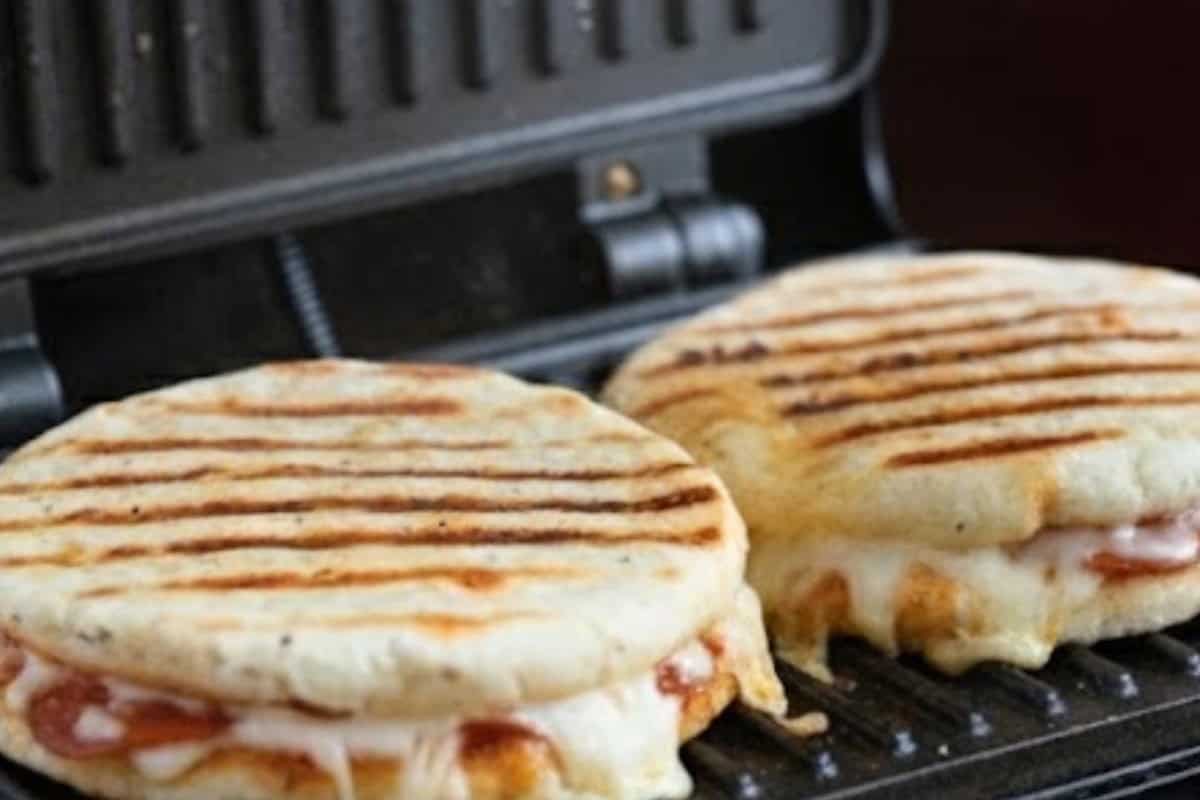 Spray the press with oil, lightly coat each sandwich, and cook until the crust turns golden and the cheese has fully melted. - 7