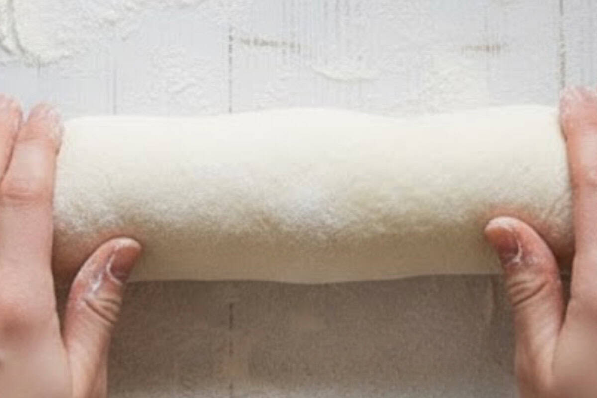 Spread half of the cooled syrup over the dough. Starting from the long edge, roll it up. If the dough sticks, use a knife to gently lift as you roll. - 8