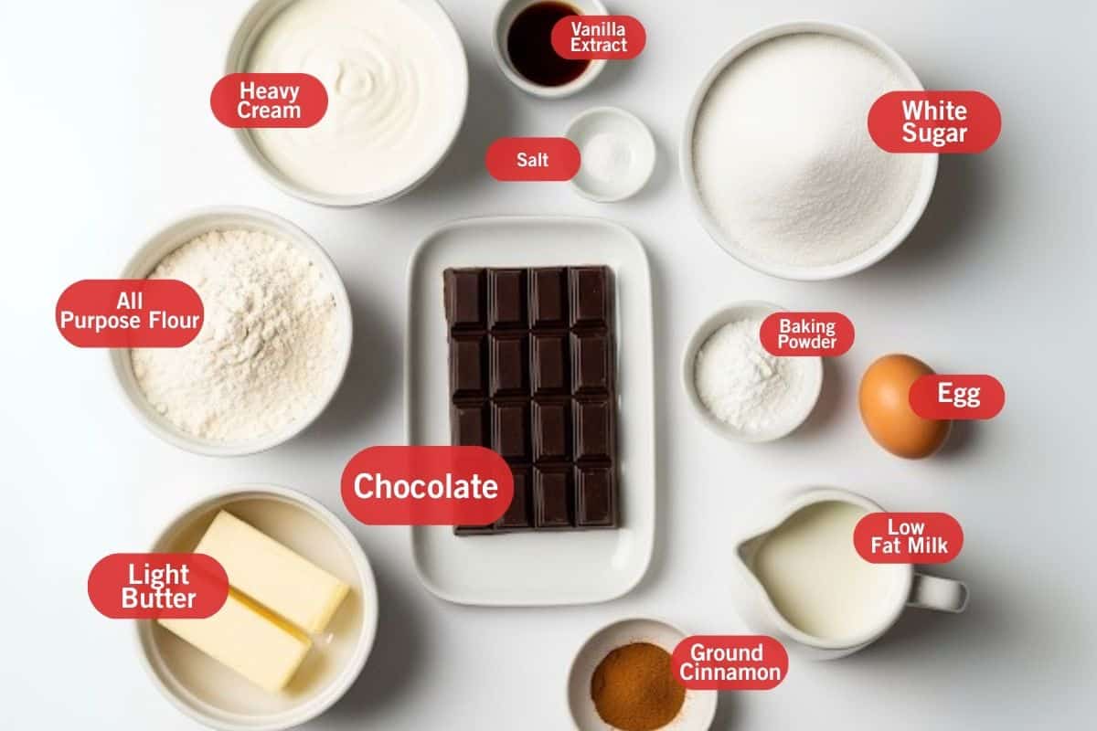 Flay lay photo of ingredient shot of heavy cream, vanilla extract, salt, white sugar, baking powder, egg, low fat milk, ground cinnamon, light butter, all purpose flour, chocolate